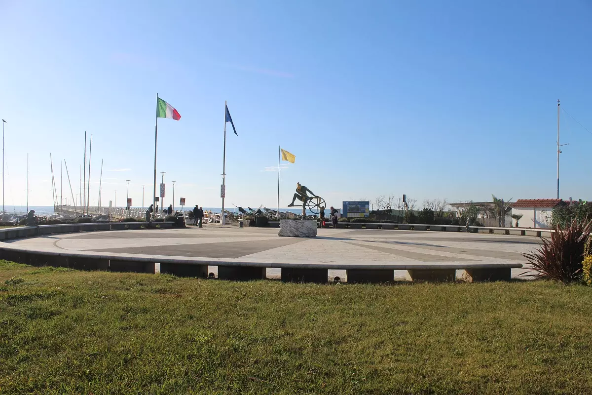 Il piazzale del pontile di Forte dei Marmi con le bandiere e la statua del ciclista