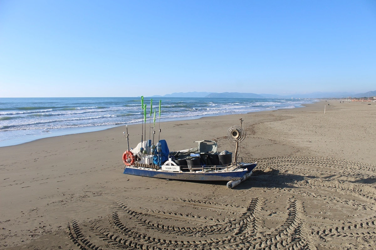 Barca da pesca sulla spiaggia di Forte dei Marmi con la costa della Versilia sullo sfondo