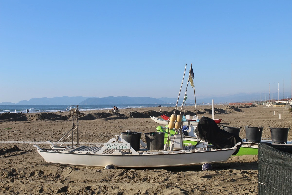 La barca da pesca Stella del Mare sulla spiaggia di Forte dei Marmi con le Alpi Apuane