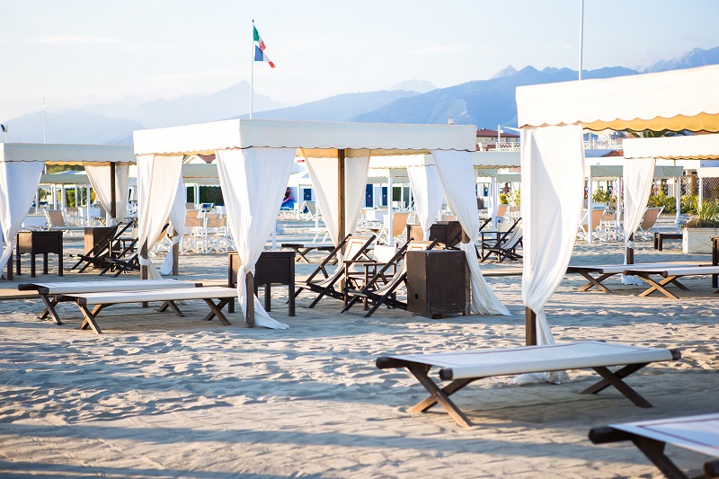 Tende e lettini di uno stabilimento balneare di Forte dei Marmi con le Apuane sullo sfondo